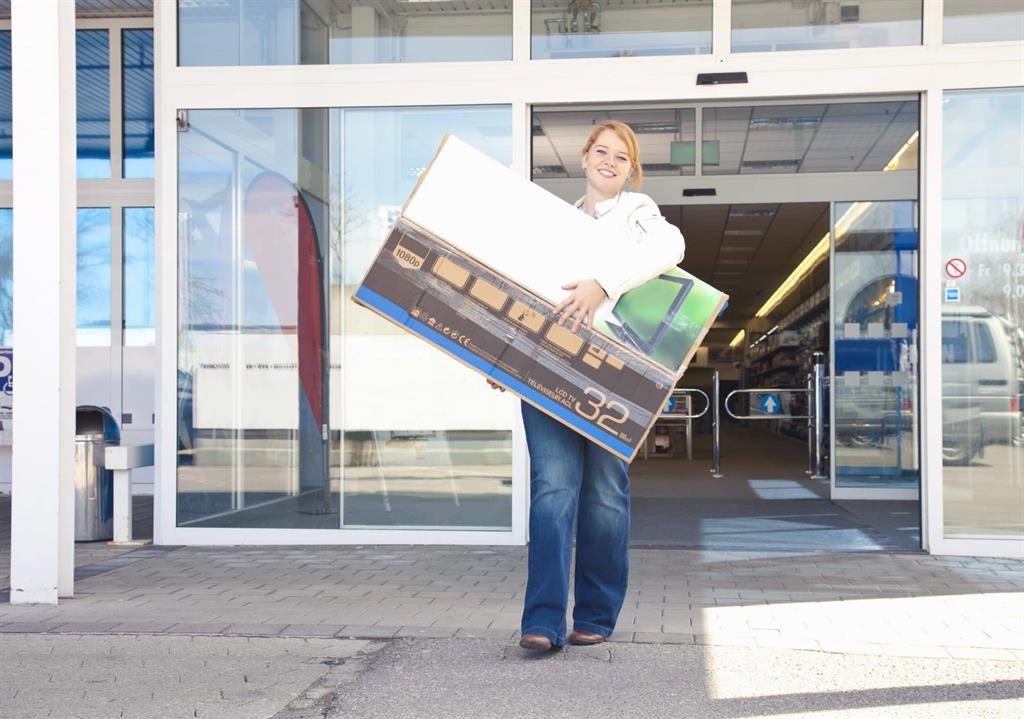 Woman carrying big tv out of a store